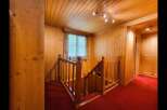 Step into a warm and inviting atmosphere with this charming wooden staircase, featuring rich red carpeting for a touch of elegance.