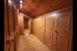 Step into this charming wooden hallway, featuring ample built-in wardrobes with elegant detailing perfect for storage.