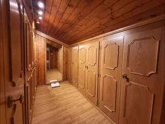 Step into this charming wooden hallway, featuring ample built-in wardrobes with elegant detailing perfect for storage.
