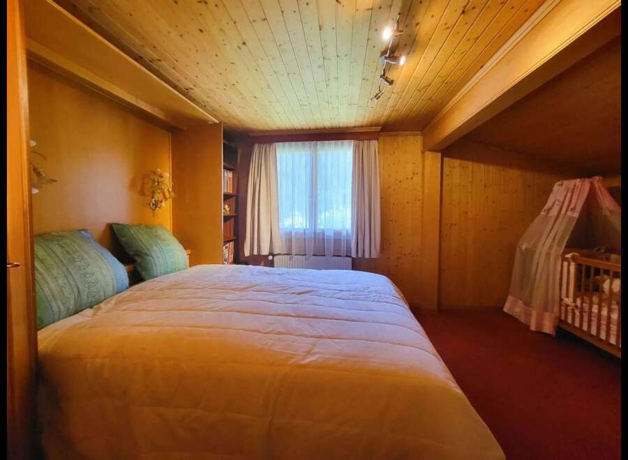 This charming bedroom features a cozy bed with plush green pillows, perfect for a restful night's sleep.