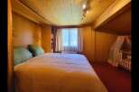 This charming bedroom features a cozy bed with plush green pillows, perfect for a restful night's sleep.