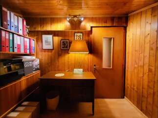 Discover this charming office space featuring warm wood-paneled walls and a cozy desk area, perfect for focused work.