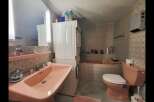 This charming bathroom features a large pink sink and a matching toilet, creating a cohesive and retro aesthetic.
