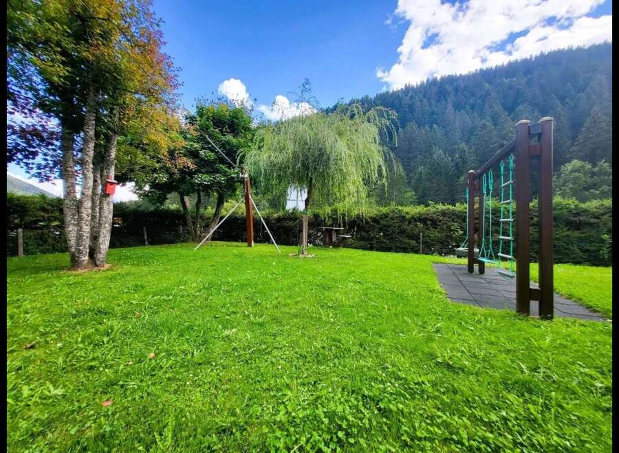 Discover this charming property featuring a lush green lawn perfect for outdoor activities and a dedicated playground area for children's enjoyment.