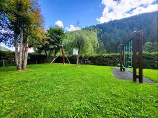 Discover this charming property featuring a lush green lawn perfect for outdoor activities and a dedicated playground area for children's enjoyment.