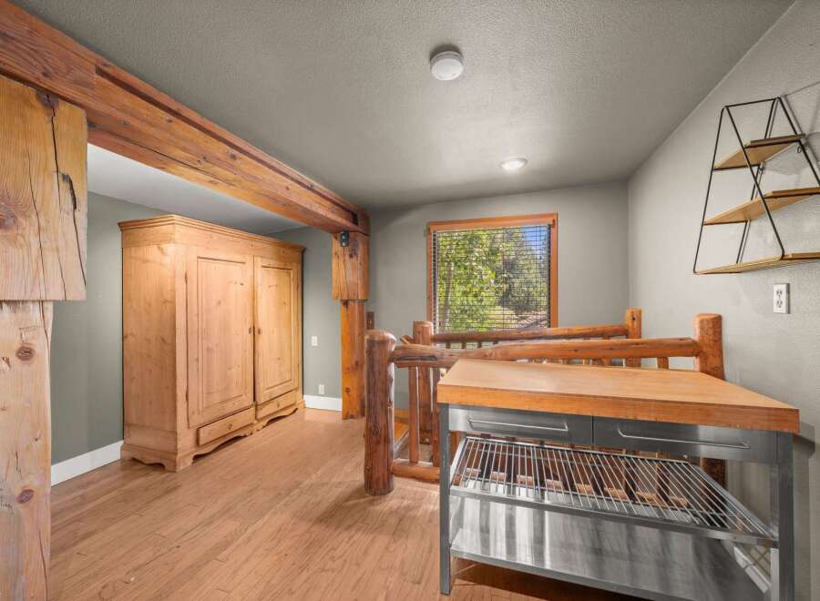 Discover rustic charm in this unique room featuring exposed wooden beams and a large, antique-style armoire.