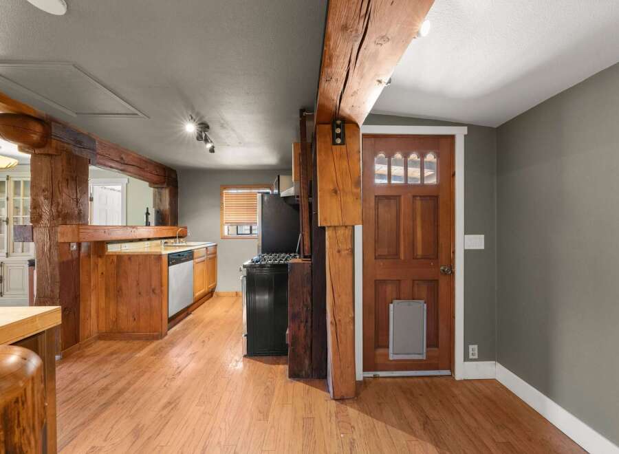 Experience rustic charm in this home featuring exposed wooden beams and a warm, inviting kitchen.