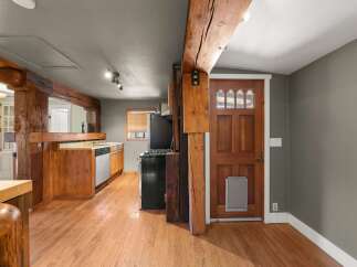 Experience rustic charm in this home featuring exposed wooden beams and a warm, inviting kitchen.