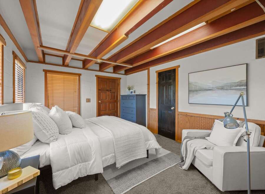 This cozy bedroom features a comfortable bed with crisp white linens, perfect for a restful night's sleep.