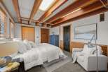 This cozy bedroom features a comfortable bed with crisp white linens, perfect for a restful night's sleep.