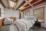 Discover this charming bedroom featuring a cozy queen-size bed adorned with plush white bedding and a textured throw.