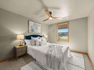 This inviting bedroom features a plush white duvet and a luxurious faux fur throw, creating a cozy and comfortable atmosphere.
