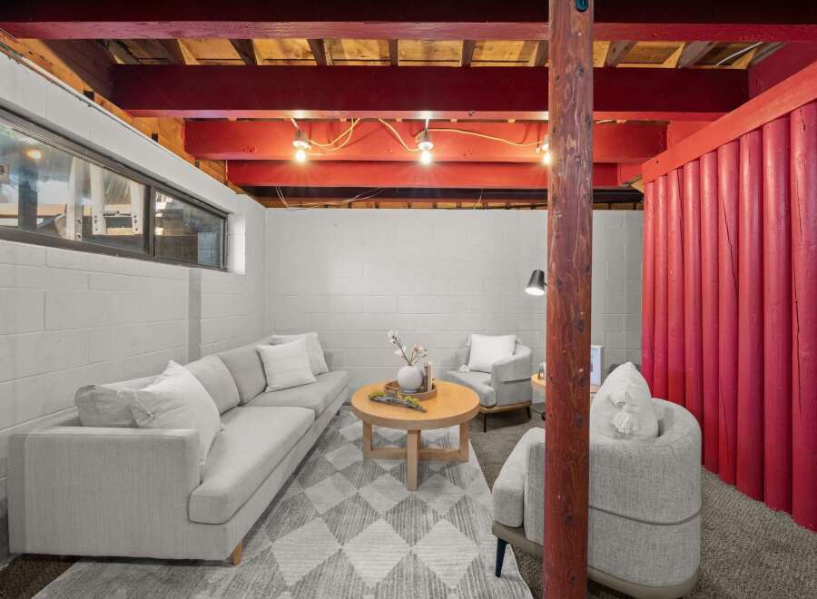 Discover comfortable living in this finished basement, featuring a cozy seating area with a plush sofa and accent chairs perfect for relaxation.