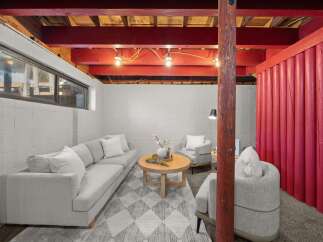 Discover comfortable living in this finished basement, featuring a cozy seating area with a plush sofa and accent chairs perfect for relaxation.