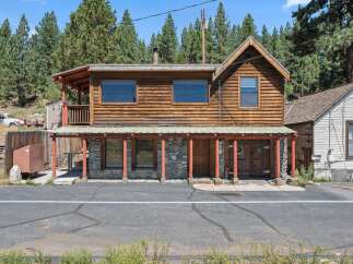 Discover this charming rustic cabin nestled amongst tall pine trees, offering a unique blend of natural beauty and cozy living.