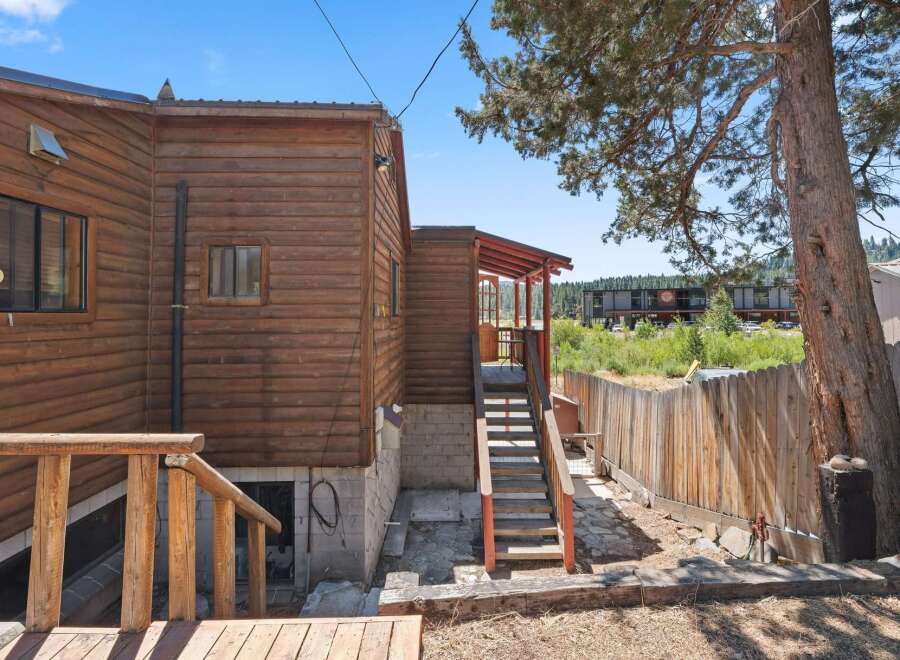 Discover this charming wooden cabin nestled amongst mature trees, offering a rustic retreat.