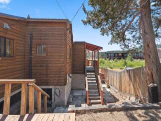 Discover this charming wooden cabin nestled amongst mature trees, offering a rustic retreat.
