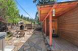 Enjoy outdoor living with this charming patio featuring a stone fireplace and comfortable Adirondack chairs, perfect for cozy evenings.