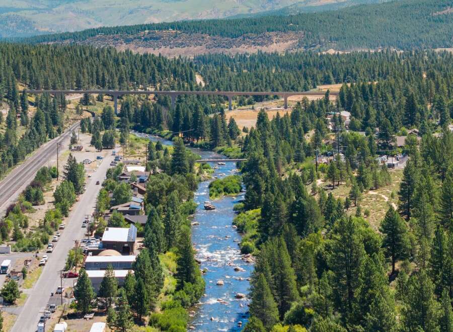 Experience the serene beauty of this riverside property, nestled amidst a lush pine forest.
