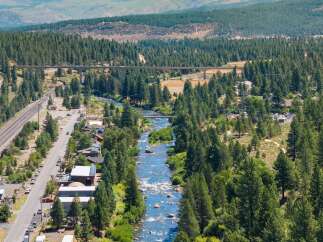 Experience the serene beauty of this riverside property, nestled amidst a lush pine forest.
