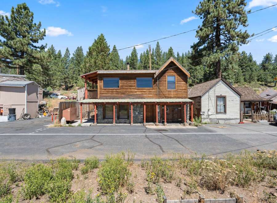Discover this charming rustic property featuring a two-story wooden building with a covered porch and stone accents on the lower level.