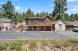 Discover this charming rustic property featuring a two-story wooden building with a covered porch and stone accents on the lower level.