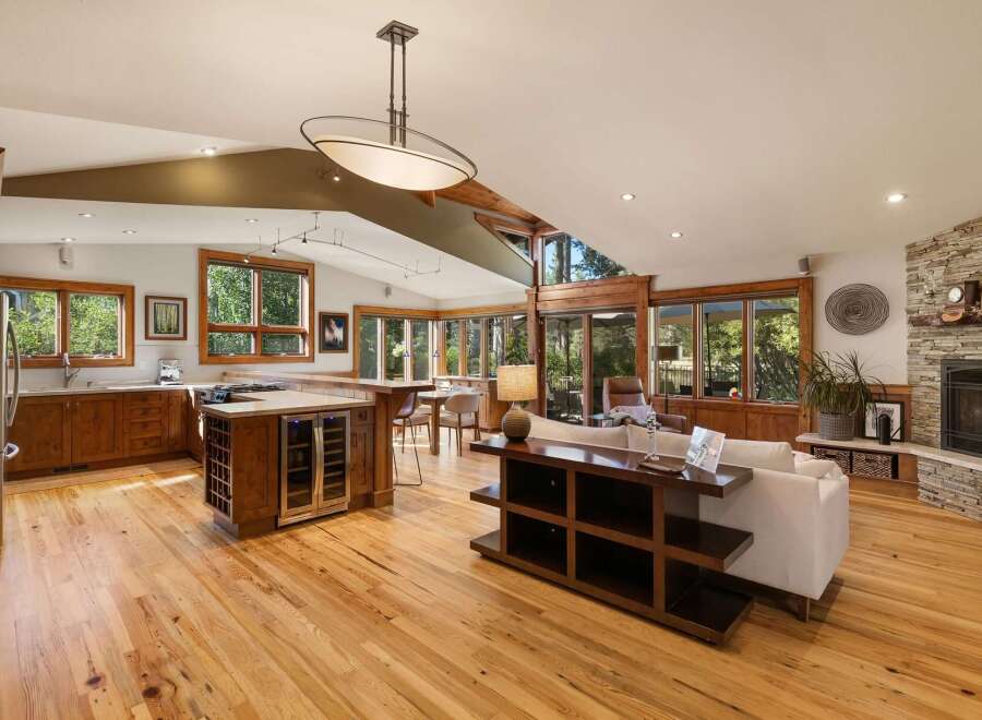 Experience open-concept living in this stunning home featuring a gourmet kitchen with a central island and wine fridge, seamlessly flowing into a spacious living area.