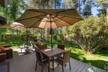 Enjoy outdoor living at its finest on this spacious deck, complete with a dining set under a large umbrella and comfortable seating areas.