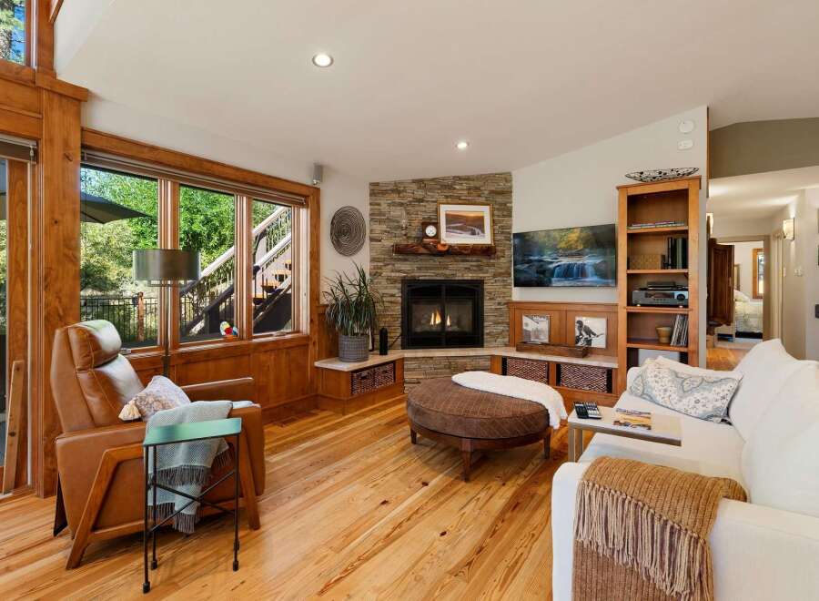 Experience cozy living in this inviting living room, featuring a stunning stone fireplace as the focal point.