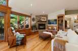 Experience cozy living in this inviting living room, featuring a stunning stone fireplace as the focal point.