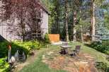 Enjoy outdoor living in this charming backyard featuring a rustic stone patio perfect for al fresco dining.