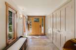 Step into this inviting entryway featuring a warm wooden front door with stained glass accents, perfect for welcoming guests.