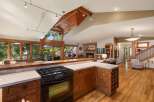 Experience the epitome of open-concept living in this stunning home, featuring a gourmet kitchen with a gas range and ample counter space, seamlessly flowing into a spacious living area with a stone fireplace.