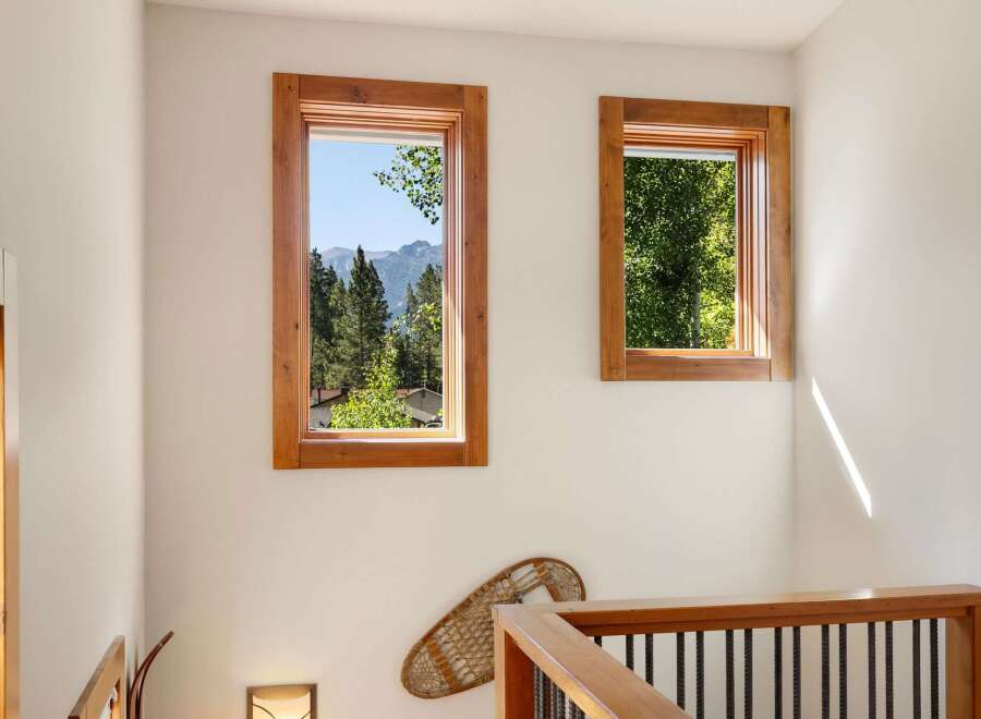 Experience breathtaking mountain views from this charming home, framed by rustic wooden windows.