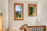 Experience breathtaking mountain views from this charming home, framed by rustic wooden windows.