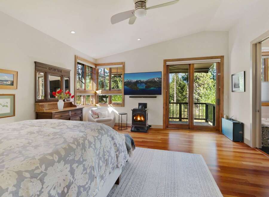 Experience ultimate comfort in this luxurious bedroom featuring a cozy gas fireplace and a large flat-screen TV for entertainment.