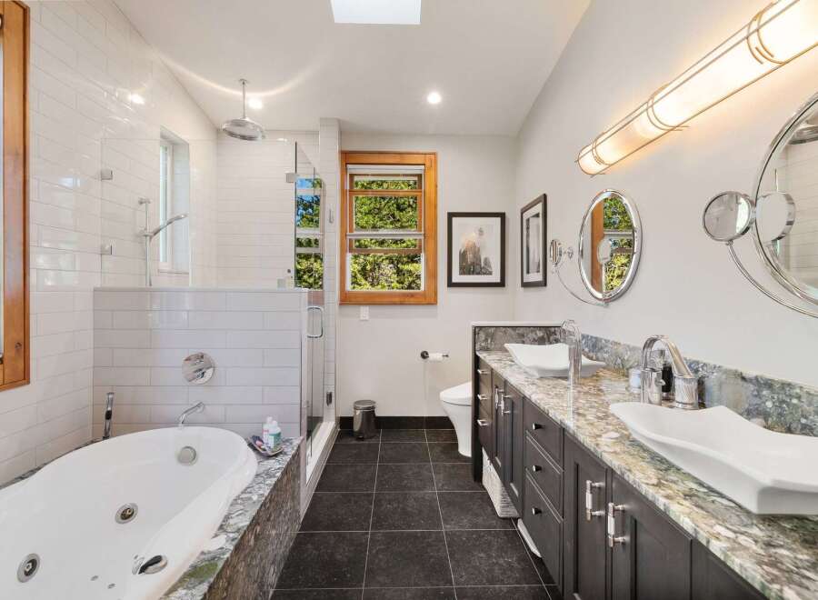 Experience luxury in this stunning bathroom featuring a deep soaking tub and a separate glass-enclosed shower.