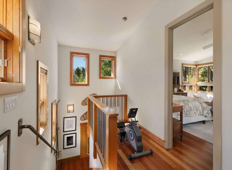 Ascend to a bright and airy upper level featuring a convenient exercise nook with a recumbent bike, perfect for maintaining your fitness routine.