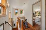 Ascend to a bright and airy upper level featuring a convenient exercise nook with a recumbent bike, perfect for maintaining your fitness routine.