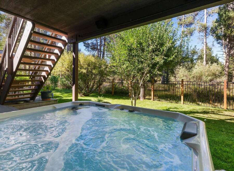 Enjoy ultimate relaxation in this stunning backyard oasis, featuring a bubbling hot tub perfect for unwinding after a long day.