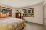 This charming bedroom features a comfortable bed with a quilted comforter, complemented by a rich wooden dresser and a decorative chair.