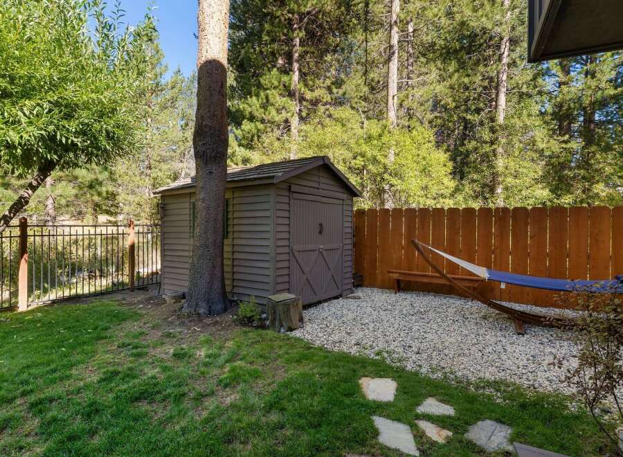 Enjoy the serene backyard oasis featuring a charming shed for storage and a relaxing hammock area perfect for unwinding.