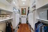 Step into this spacious walk-in closet, featuring ample white shelving and drawers for organized storage.