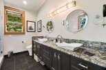 This luxurious bathroom features a spacious double vanity with elegant vessel sinks and granite countertops.