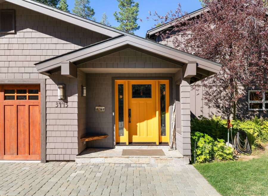 Welcome to this charming home featuring a vibrant yellow front door, perfect for creating a warm and inviting atmosphere.