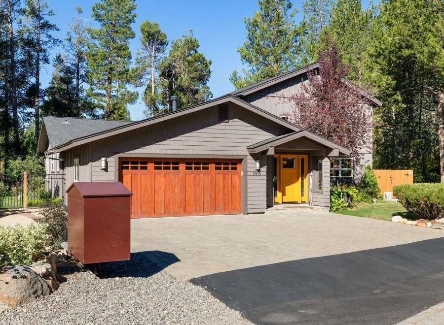 Charming home featuring a striking bright yellow front door that welcomes you into the property.