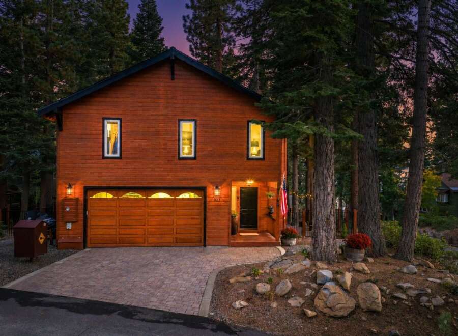 Nestled amongst tall pine trees, this charming wooden home offers a warm and inviting ambiance.