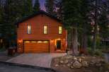 Nestled amongst tall pine trees, this charming wooden home offers a warm and inviting ambiance.