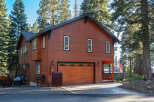 Discover this charming wooden home nestled among tall pine trees, offering a serene mountain retreat.