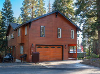 Discover this charming wooden home nestled among tall pine trees, offering a serene mountain retreat.